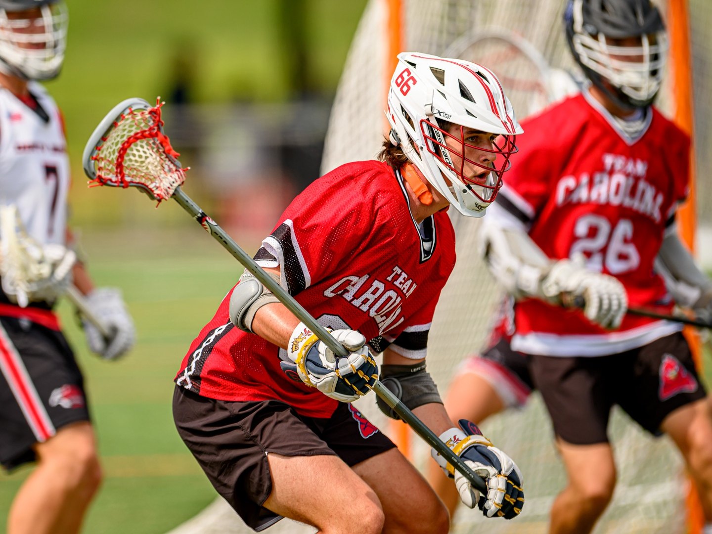 Team Carolina #66 driving the cage in red Team Carolina jersey during a summer tournament