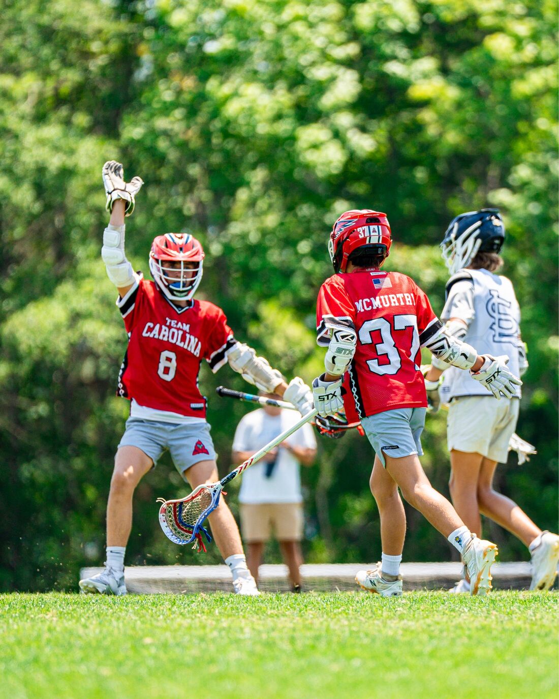 Team Carolina players celebrating a goal during a boys travel lacrosse game